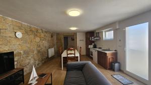a living room with a couch and a stone wall at Casa Maripaula Caminheiros in Belinho