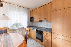 a kitchen with wooden cabinets and a table and a window at Haus Meeresrauschen, Whg 1 in Duhnen