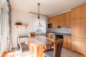 a kitchen with a wooden table and chairs and a table and a table and chairs at Haus Meeresrauschen, Whg 1 in Duhnen