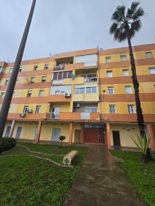 an apartment building with a palm tree in front of it at Bellavista in La Línea de la Concepción