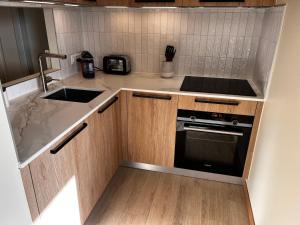 a small kitchen with a sink and a stove at Beautiful mountain apartment in Leysin