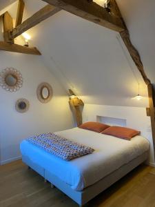 a bedroom with a large bed in a attic at Le Logis de la Lettre in Tinténiac