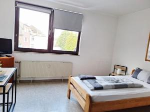 a bedroom with a bed and a large window at Gästezimmer B in Mönchengladbach