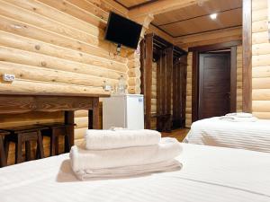 een kamer met 2 bedden en handdoeken op het bed bij Джерело in Brody