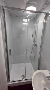 a shower with a glass door next to a sink at Comfort Lodge in Nottingham