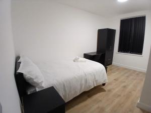 a bedroom with a white bed and two speakers at Comfort Lodge in Nottingham