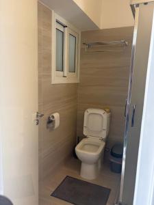 a small bathroom with a toilet and a window at Rimini Balcony Studios - Steps from the Sea in Paphos +23 photos
