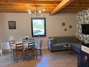 een woonkamer met een tafel en een bank bij Domki Gorąca Bania in Gowidlino