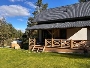 een huis met een houten veranda en een prieel bij Domki Gorąca Bania in Gowidlino