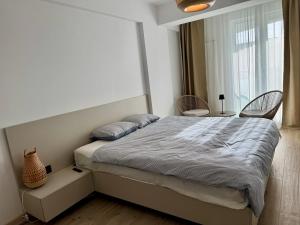 a bedroom with a bed with two chairs and a window at Alezzi Infiniti Resort & SPA - SUNRISE 349 in Năvodari +23 photos