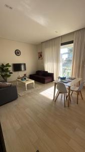 a living room with a table and a couch at Cosy 1BR with a PUBLIC POOL and WIFI in Ma‘mūrah