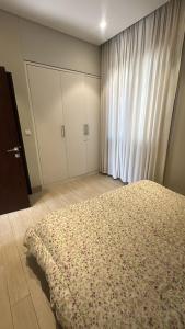 a bedroom with a bed and a large window at Cosy 1BR with a PUBLIC POOL and WIFI in Ma‘mūrah +9 photos