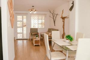 una sala da pranzo e un soggiorno con tavolo e sedie di Casa del Mar Malin a Ballenita