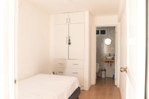 una camera bianca con letto e armadio di Casa del Mar Malin a Ballenita Altre 19 foto