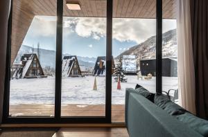 a living room with a view of a snow covered yard at WinterFell Mestia in Mestia +56 photos