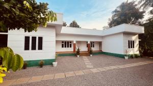 a white house with plants in the courtyard at Green Villa Chirackal Gardens in Trichūr