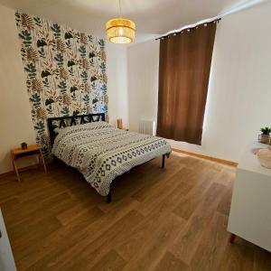 una camera da letto con un letto e un pavimento in legno di Maison rénovée 6 pers avec Wi-Fi et parking a Arthun