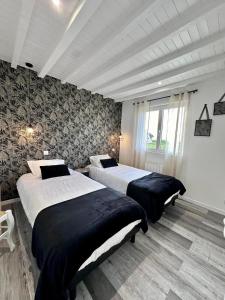 a bedroom with two beds and a large window at Gite EGLANTINE in Saint-Rémy-Boscrocourt