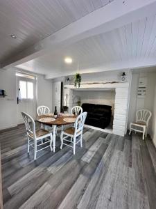 a dining room with a table and chairs and a fireplace at Gite EGLANTINE in Saint-Rémy-Boscrocourt