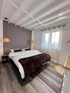 a bedroom with a large bed and a large window at Gite EGLANTINE in Saint-Rémy-Boscrocourt