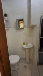 a small bathroom with a toilet and a sink at Casa privada no Centro in São Gabriel