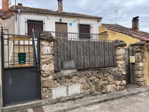 een stenen muur met een poort en een gebouw bij La Casa de Fausto en Basardilla in Basardilla