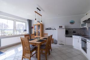 a kitchen with a wooden table and chairs in a room at Haus Vogelsand, App 309 in Duhnen