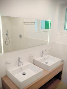 a bathroom with two sinks and a large mirror at green Home - Sonniges Chalet in den Alpen in Kirchberg in Tirol +14 photos