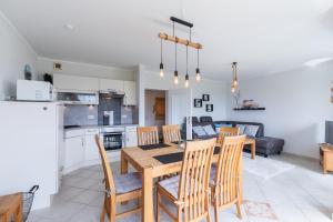 a kitchen and dining room with a wooden table and chairs at Haus Vogelsand, App 309 in Duhnen