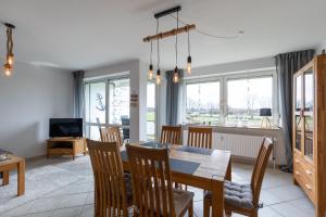 a dining room and living room with a table and chairs at Haus Vogelsand, App 309 in Duhnen