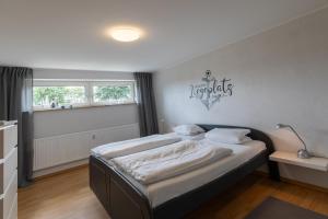 a bedroom with a bed with a nautical sign on the wall at Haus Vogelsand, App 309 in Duhnen