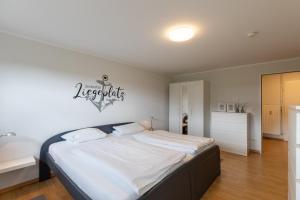 a bedroom with a bed with a nautical sign on the wall at Haus Vogelsand, App 309 in Duhnen +22 photos