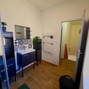 un bagno con lavandino e specchio di Maison rénovée 6 pers avec Wi-Fi et parking a Arthun Altre 7 foto