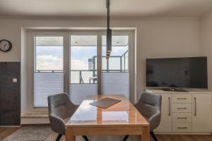 a dining room with a table and chairs and a television at Haus Medemsand, Whg 221 in Duhnen
