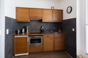 a kitchen with wooden cabinets and a sink and a clock at Haus Medemsand, Whg 221 in Duhnen