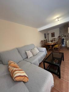 een woonkamer met een grijze bank en een tafel bij La Casa de Fausto en Basardilla in Basardilla