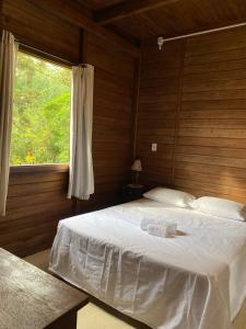 a bedroom with a large bed with a window at Ebenezer in Benedito Novo