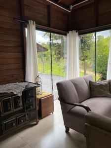 a living room with a couch and a large window at Ebenezer in Benedito Novo