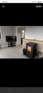 a living room with a fireplace and a television at Seaview House in Donegal