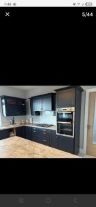 a kitchen with blue cabinets and a stove top oven at Seaview House in Donegal