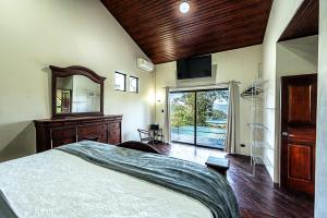 a bedroom with a bed and a dresser and a mirror at Arenal Summit in Nuevo Arenal +53 photos