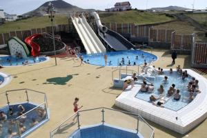 a group of people in a pool at a water park at Þórsheimili - Rooms in Vestmannaeyjar +18 photos