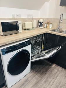 a microwave and a dishwasher in a kitchen at The Luxe Haven Penthouse - Sleeps 4 Apartment Nottingham City Centre in Nottingham