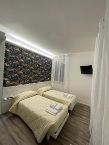 een slaapkamer met twee bedden en een schilderij aan de muur bij La Casa Sul Viale in Iesi