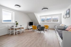 a white living room with a table and chairs at Horský sen - Mountain Dream Apartment B1 in Špičák