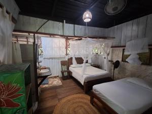 a bedroom with two beds and a table at Maloka Napü - Ecodestinos in Puerto Nariño