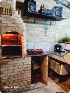 a kitchen with a brick fireplace with a pizza oven at Varanda Praiana in Rio das Ostras