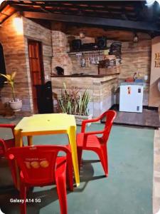 a yellow and red table and chairs in a room at Varanda Praiana in Rio das Ostras