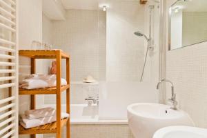 ein Badezimmer mit einer weißen Badewanne und einem Waschbecken in der Unterkunft Hotel Diamonds and Pearls in Antwerpen