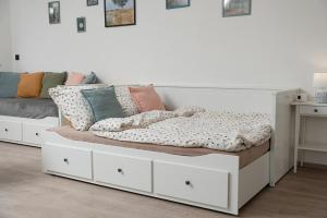a white bed with white drawers and pillows on it at Horský sen - Mountain Dream Apartment B1 in Špičák